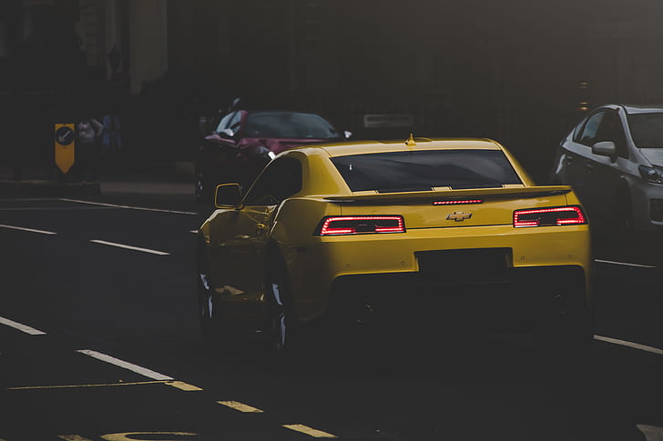 yellow Chevrolet Camaro at the city road