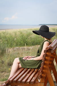 woman sitting on brown wooden bench