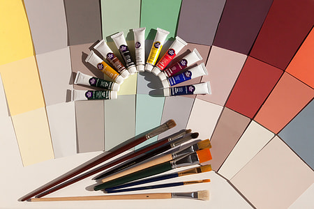 photo of assorted-color paint brushes and paint color soft tubes
