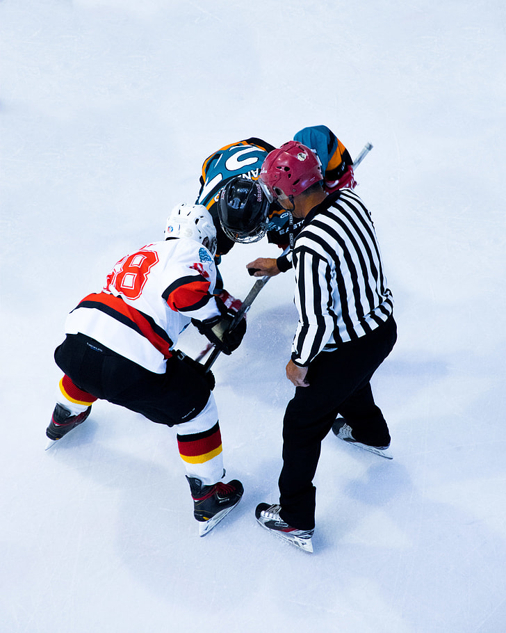 two ice hockey players and referee