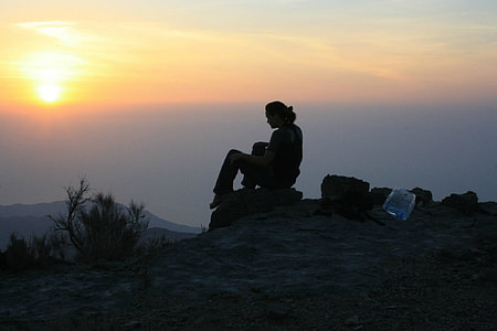 woman on top of mountain during sunset