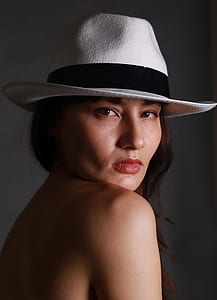 woman wearing black and white pedora hat