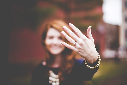 person in black showing her hand with ring
