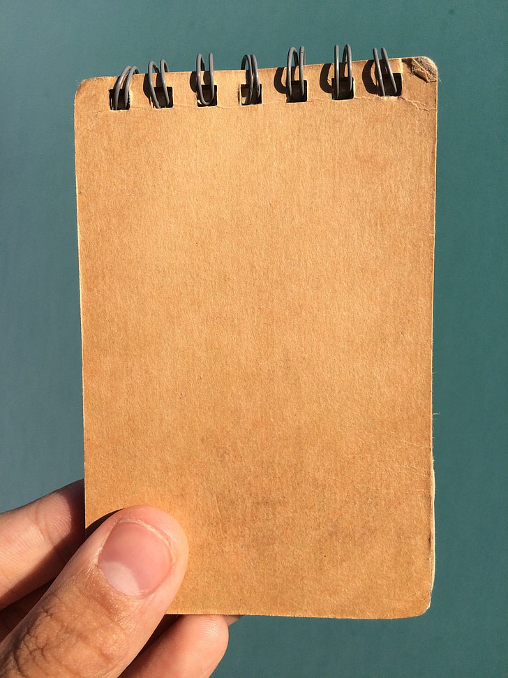 person holding brown book cover