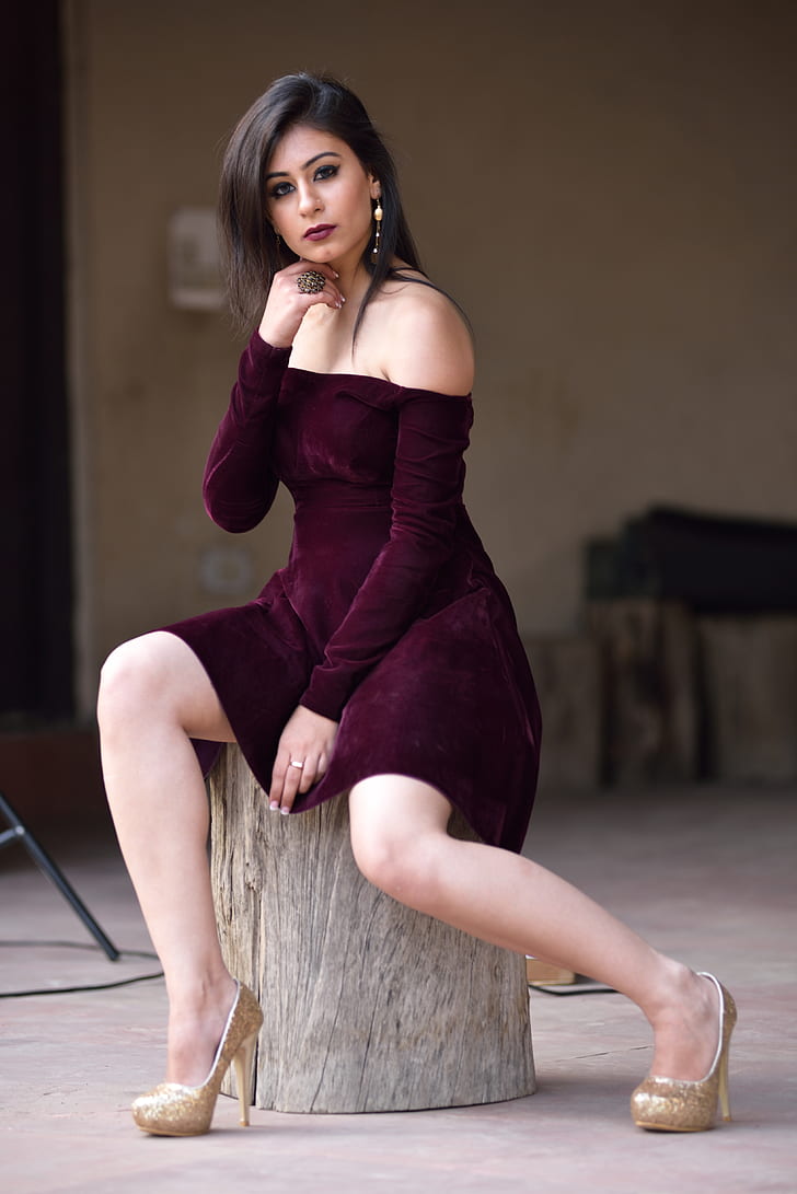 woman in maroon dress sitting on wood