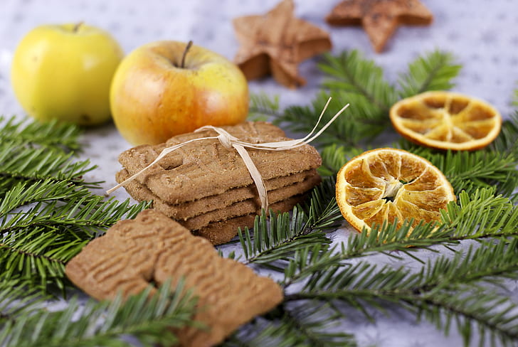 four cookies with tie beside two yellow apple fruits