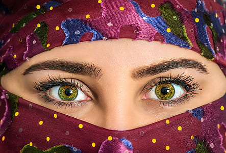 close-up photography of woman wearing pink, blue, yellow, and green polka-dot camouflage hijab headscarf