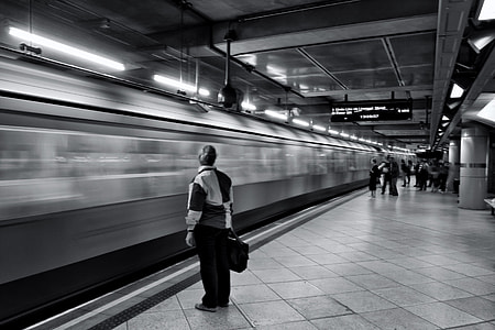A passenger waits for the arriving train on the platform of the London Underground rail network