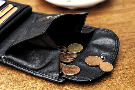 assorted coins on black leather wallet