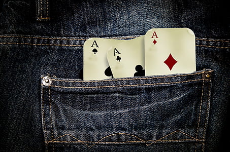 closeup photo of three gaming card on pocket