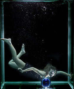 photo of woman underwater looking on clock