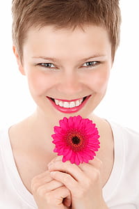 woman holding pink Gerbera daisy flower