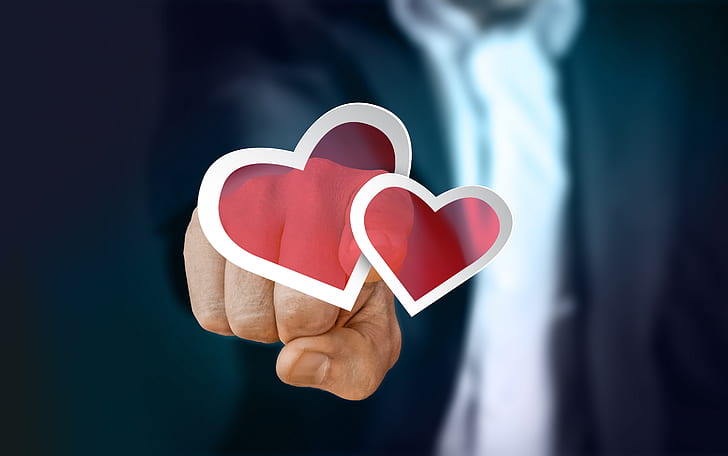 person pointing two red hearts illustration