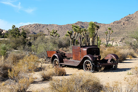 classic brown car left on desert during daytime