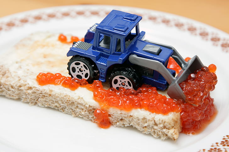 blue and grey skid loader toy on top of cake