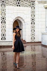 woman wearing black sleeveless dress and hat