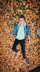 Closeup Photo of Man Lying on Brown Leaves