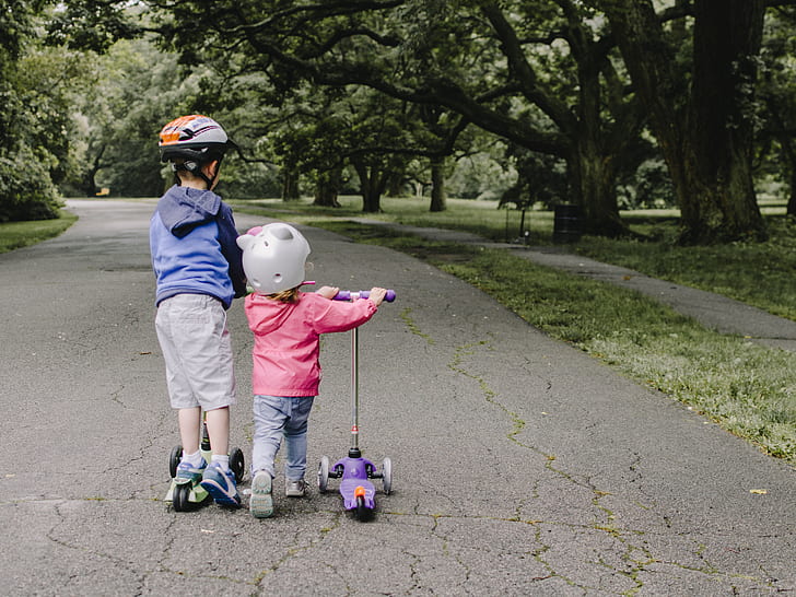 two children's playing kick scooters