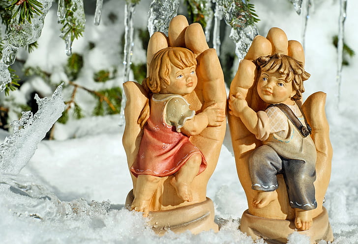 two boy and girl figurines on snow covered surface