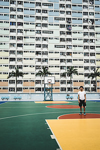 green, red, and yellow basketball court beside white building