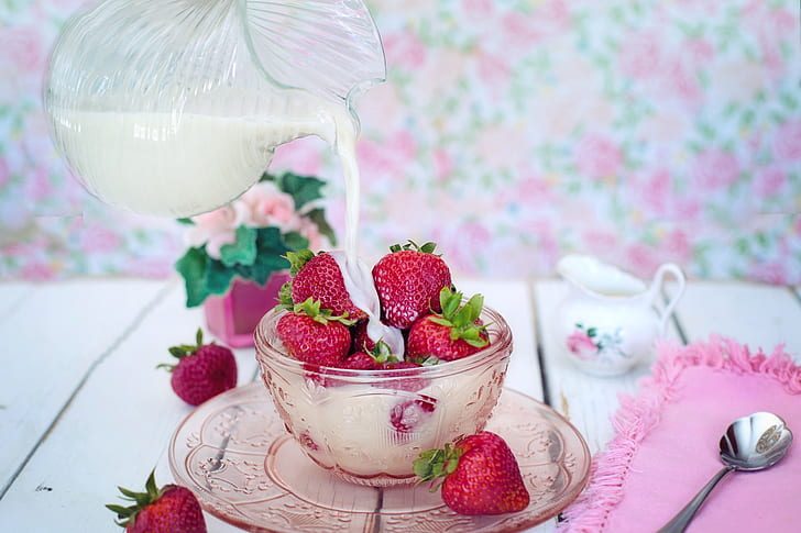 strawberries on cup poured with milk