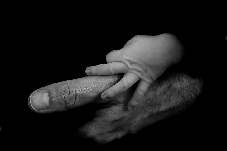 grayscale photo of baby holds man's hand