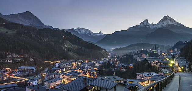 high angle photo of town buildings and mountain under dim sky