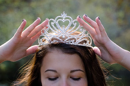 woman holding crown on head