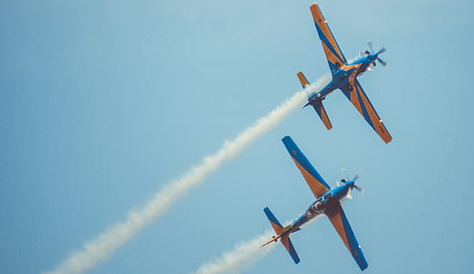 two blue-and-brown airplanes at the sky during day