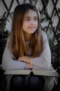 girl wearing sweater and leaning on the book