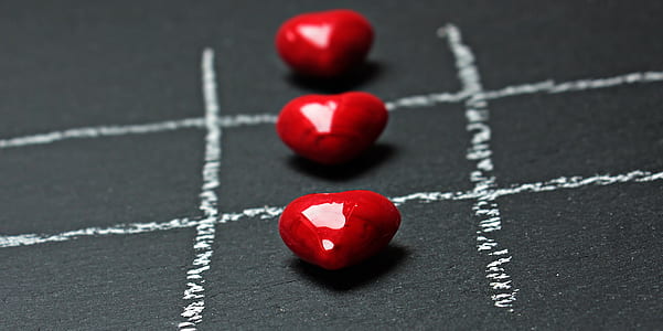 close up photo of three heart-shaped red stones