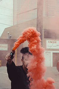 man holding a smoke grenade