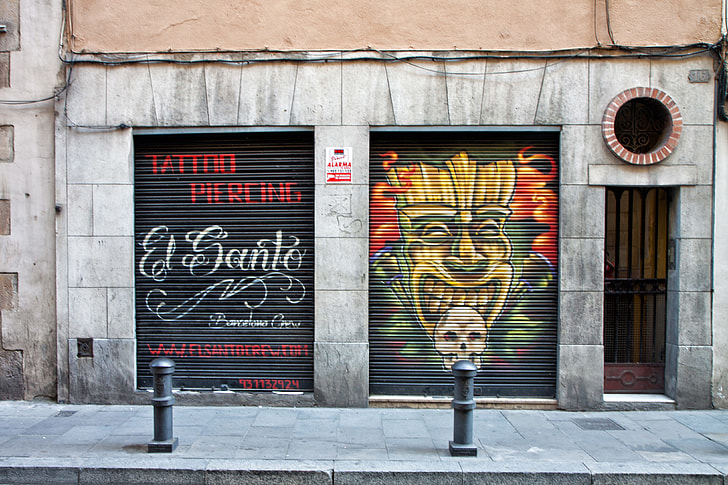 Tattoo and piercing shop with street art in Barcelona, Spain