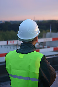 man in green high-visibility vest with white hard hat