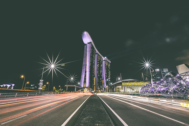 time lapse photography at center island of highway next to Marina Bay Sands during night time