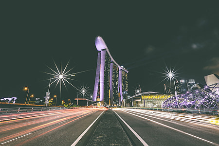 time lapse photography at center island of highway next to Marina Bay Sands during night time