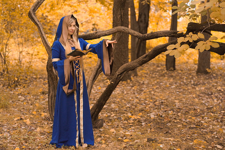 woman dressed as a wizard in the forest casting a spell