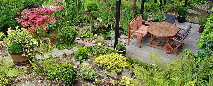 empty brown wooden chairs and table in the middle of garden