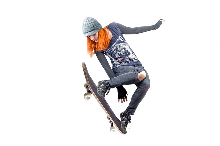 woman in blue and black long-sleeved shirt using skateboard
