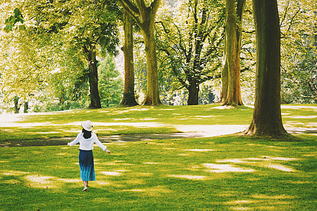 Woman walking in a tree-lined park