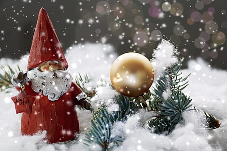 Santa Claus figure on snowfield beside gold-colored ornament