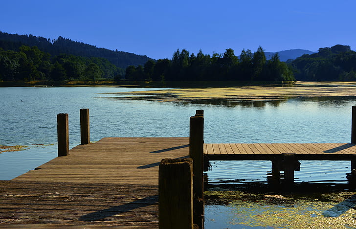 brown wooden dock on body of water at daytime