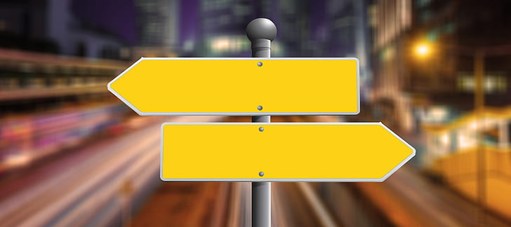 selective focus photography of two yellow arrow signages