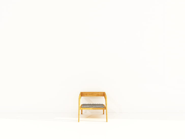 brown wooden framed padded chair beside white wall