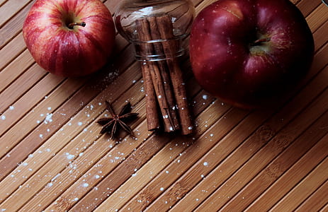 two apple fruits on brown wooden surface