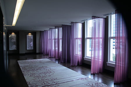 room with purple curtains and floral area rug