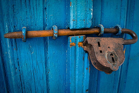 brown steel padlock on blue wooden door