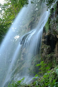 waterfalls with green plant on the rock mountain