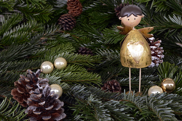 angel, pinecone and bauble ornaments hanged on christmas tree