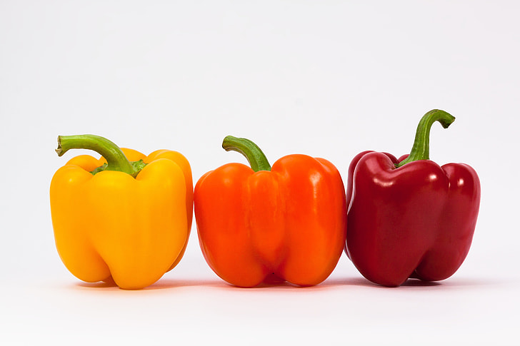 three bell peppers on white surface